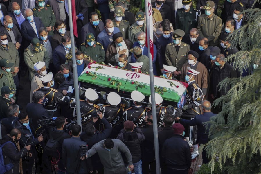 In this photo released by the official website of the Iranian Defense Ministry, military personnel carry the flag draped coffin of Mohsen Fakhrizadeh, a scientist who was killed on Friday, in a funeral ceremony in Tehran, Iran, Monday, Nov. 30, 2020.