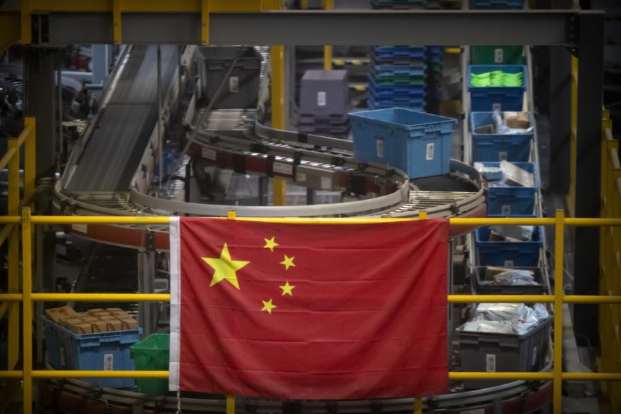 FILE - In this Nov. 11, 2020, file photo a Chinese flag hangs near an automated parcel handling line at a warehouse for an online retailer in Beijing. President Donald Trump has identified China as the country&#039;s biggest foe and the Justice Department mirrored that emphasis over the last four years with a drumbeat of cases against defendants ranging from hackers accused of targeting intellectual property to professors charged with grant fraud.