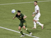 Portland Timbers defender Marco Farfan, left, heads the ball away from in front of the goal as Colorado Rapids forward Andre Shinyashiki looks on during the first half of an MLS soccer match in Portland, Ore., Wednesday, Nov. 4, 2020.