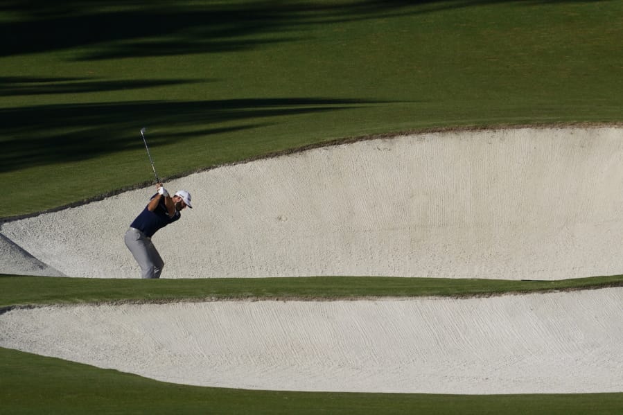 Dustin Johnson hits out of a bunker on the eighth hole during the second round of the Masters golf tournament Friday, Nov. 13, 2020, in Augusta, Ga. (AP Photo/David J.