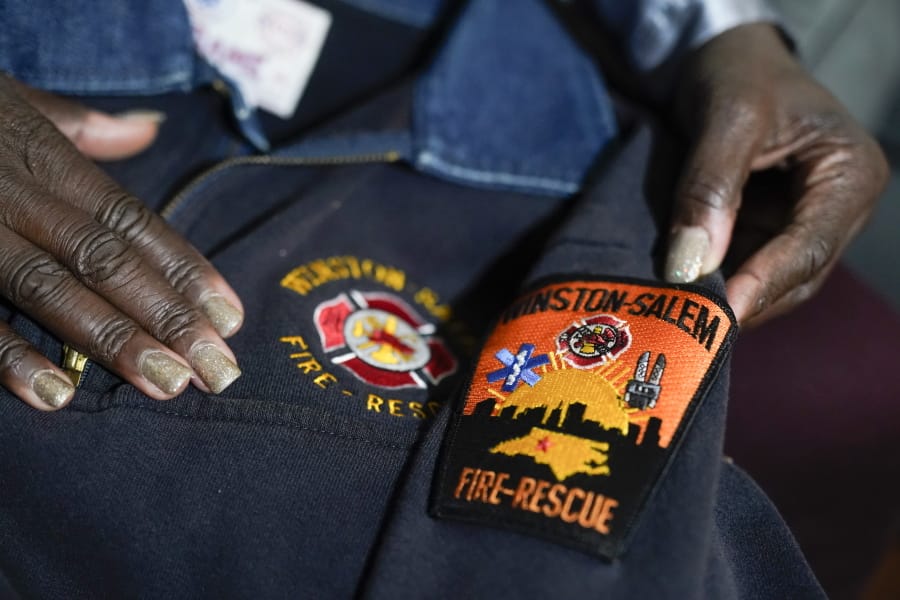 Timika Ingram holds a jacket she had when she was a firefighter on Thursday, Nov. 19, 2020, in Charlotte, N.C. A group of Black firefighters in a North Carolina city have filed a grievance over conditions they have endured for more than 30 years.