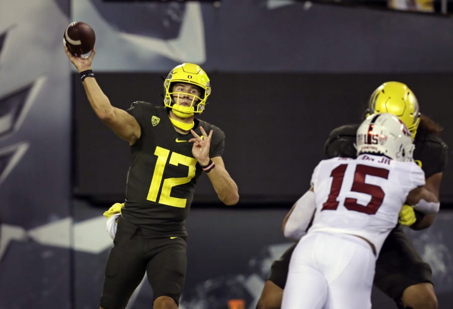 Oregon&#039;s Tyler Shough, left, throws downfield against Stanford during the second quarter of an NCAA college football game Saturday, Nov. 7, 2020, in Eugene, Ore.