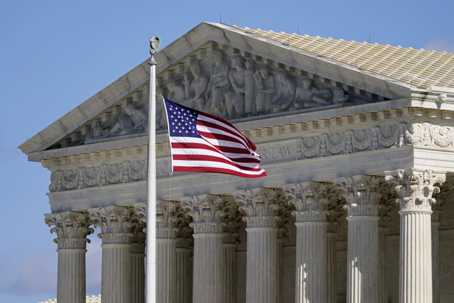 FILE - In this Nov. 2, 2020, file photo an American flag waves in front of the Supreme Court building on Capitol Hill in Washington. The Supreme Court is hearing arguments over whether the Trump administration can exclude people in the country illegally from the count used for divvying up congressional seats.