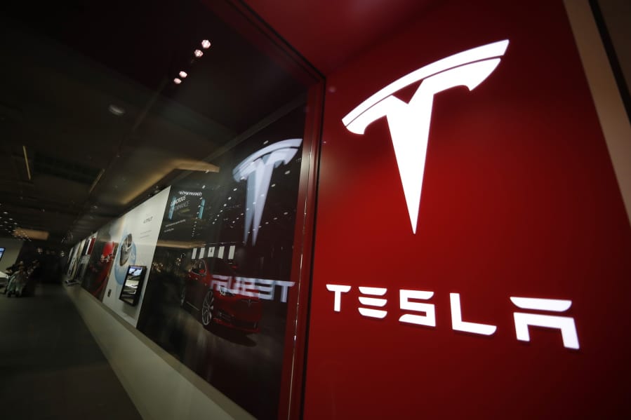 FILE - In this Feb. 9, 2019, file photo, a sign bearing the company logo stands outside a Tesla store in Cherry Creek Mall in Denver. U.S. safety regulators are continuing their investigation into complaints that Tesla&#039;s giant touch screens can fail and cause the cars to lose the rear camera display and other functions. A preliminary investigation was opened in June 2020 covering 63,000 Model S vehicles.