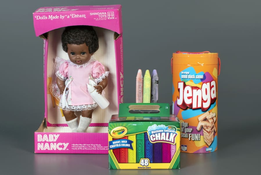 This photo, provided by the National Toy Hall of Fame, shows Baby Nancy, by Shindana Toys; Sidewalk Chalk, by Crayola; and Jenga, by Parker Brothers, left to right, that were inducted into the National Toy Hall of Fame on Thursday, Nov, 5, 2020. The honorees were chosen by a panel of experts from among 12 finalists and will be on permanent display inside The Strong National Museum of Play, in Rochester, New York.
