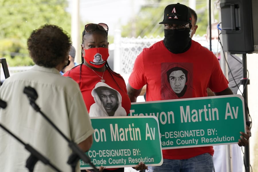 Sybrina Fulton, center and Tracy Martin, parents of Trayvon Martin, hold street signs with their son&#039;s name, Thursday, Nov. 5, 2020, in Miami Gardens, Fla. The street on the way to Martin&#039;s former school was renamed in his honor, eight years after he was killed by a neighborhood watch volunteer in Sanford, Fla.