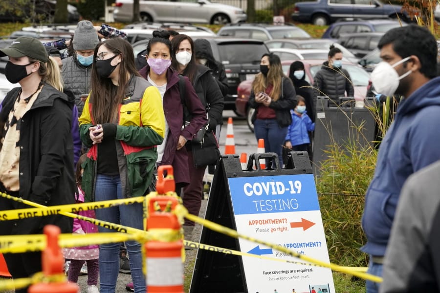 People line up Wednesday to be tested for the coronavirus at a free testing site in Seattle. With the new restrictions on indoor gatherings that require members of other households to quarantine or get a negative COVID-19 test and families hoping to gather safely for Thanksgiving, long lines to get tested have reappeared.