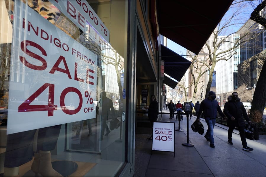 Shoppers pass an Indigo Friday 40% Off sign Saturday, Nov. 28, 2020, on Chicago&#039;s famed Magnificent Mile shopping district.