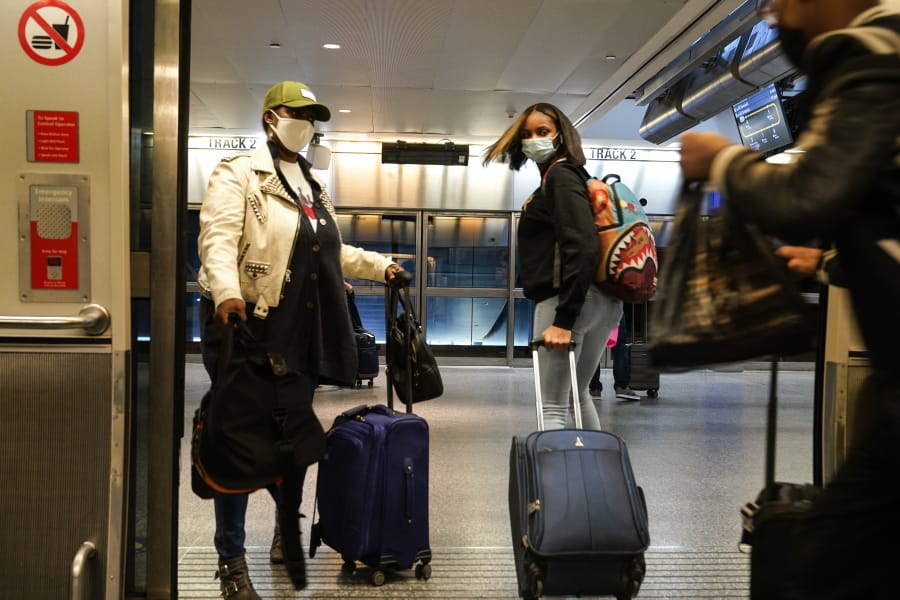 Travelers leave the AirTrain at JKF International Airport Friday, Nov. 20, 2020, in New York. Rising U.S. coronavirus cases, a new round of state lockdowns and public health guidance discouraging trips are dampening enthusiasm for what is usually the biggest travel period of the year.