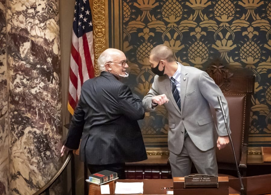 FILE - In this Nov. 12, 2020 file photo, outgoing Senate President Senate President Jeremy Miller, R-Winona gave Sen. David Tomassoni, DFL-Chisholm a congratulatory elbow bump before Tomassoni addressed the Senate Chamber. At least 187 state legislators nationwide have tested positive for the virus and four have died since the pandemic began, according to figures compiled by The Associated Press. Twelve Arkansas lawmakers have tested positive for the virus over the past month, the second largest known outbreak in a state legislature.