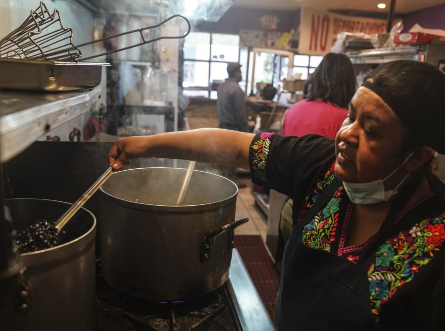 Natalia Mendez cooks in the kitchen of La Morada, an award winning Mexican restaurant she co-owns with her family in South Bronx, Wednesday Oct. 28, 2020, in New York. After recovering from COVID-19 symptoms, the family raised funds to reopen the restaurant, which they also turned into a soup kitchen serving 650 meals daily.