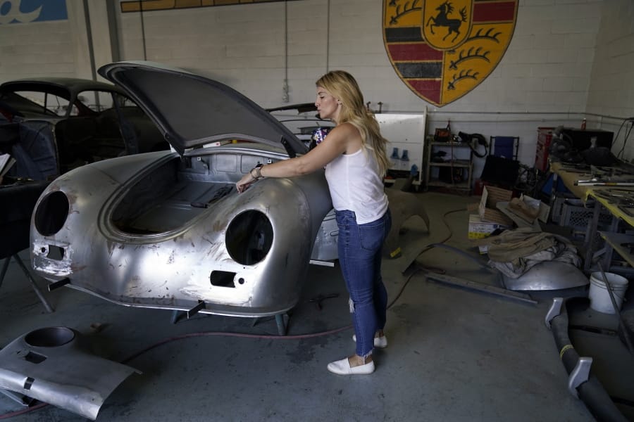 Laurina Esposito, co-owner of Espo Restoration, which specializes in restoring Porsches, inspects a frame at her shop Monday, Oct. 19, 2020, in the North Hollywood section of Los Angeles. Esposito and her business partner were diagnosed with coronavirus in early September. She was very ill for three weeks and did as much work as she could on her laptop in bed, but at times was too exhausted.