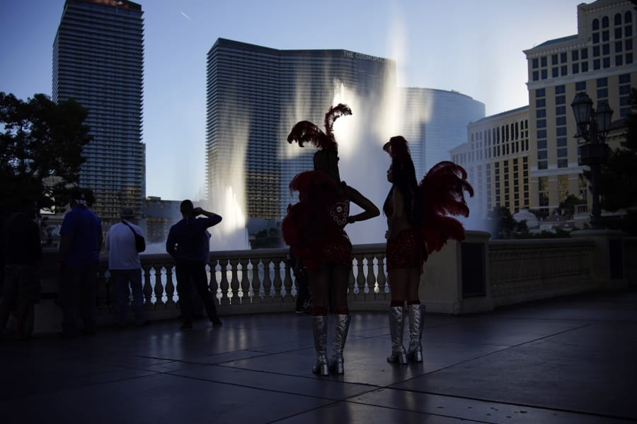 People walk along the Las Vegas Strip, Thursday, Nov. 19, 2020, in Las Vegas. As the coronavirus surges to record levels in Nevada, the governor has implored residents to stay home. But Democrat Steve Sisolak has also encouraged out-of-state visitors, the lifeblood of Nevada&#039;s limping economy, to come to his state and spend money in Las Vegas.