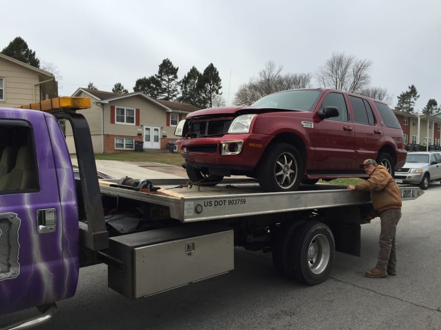 Bruce Goacher of Davenport, Iowa, hoists a repossessed car onto his tow truck on Dec. 6, 2015 in Bettendorf, Iowa.