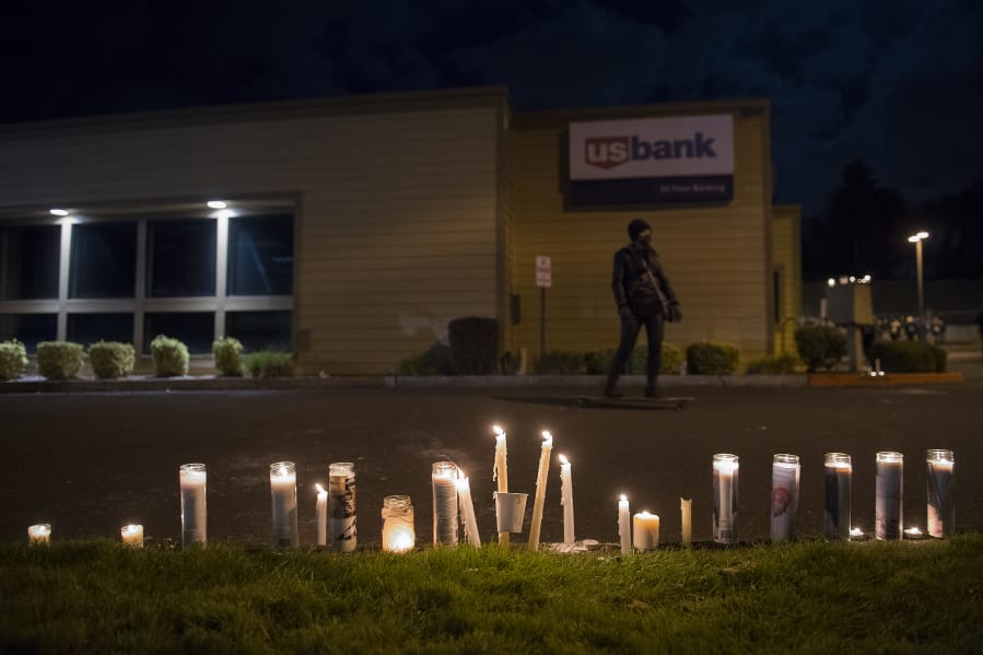 Candles in memory of Kevin Peterson Jr. are seen at the Hazel Dell branch of U.S. Bank on Oct. 30.