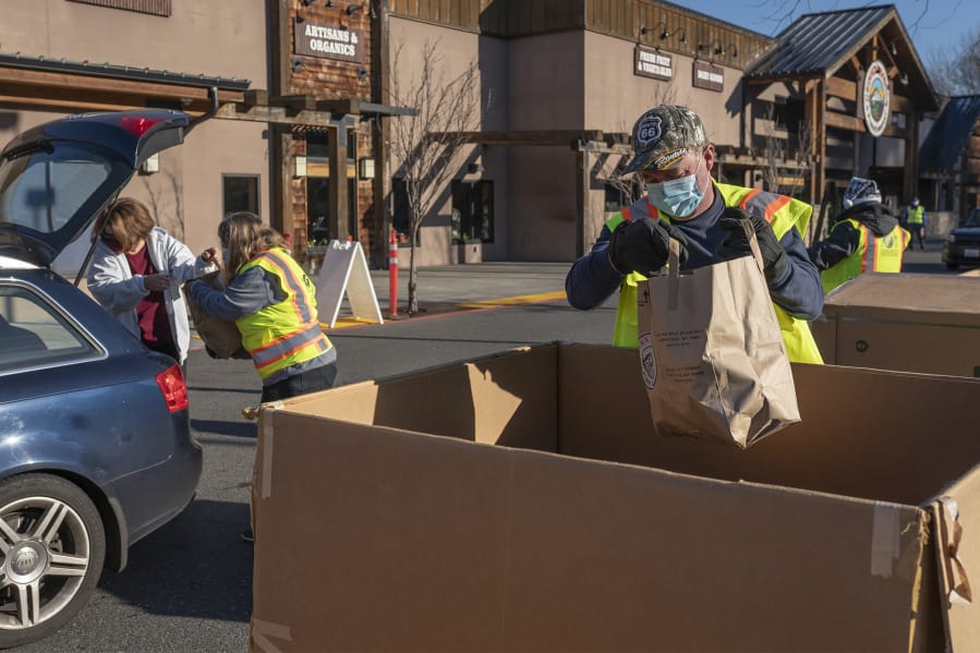 Volunteers unpack food donations from a car at the Salmon Creek Drive &amp; Drop location Saturday morning. Volunteers manned eight locations throughout the county for the annual food drive.