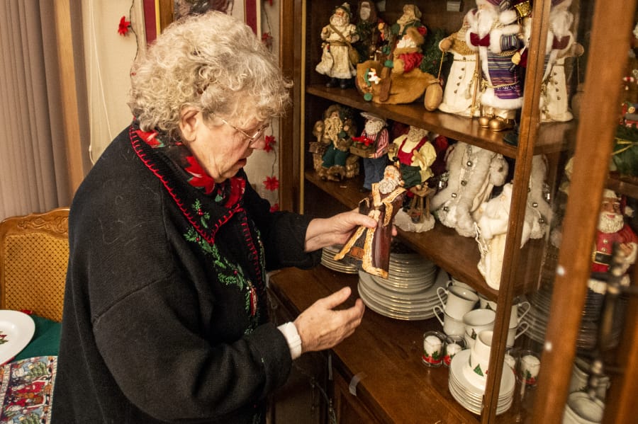 Joanna Hamnes, 79, shows off a tin Santa figurine, which could be more than 80 years old and was passed to her by her mother. It was the first in a collection of figurines that now numbers more than 100.