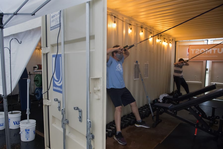 Zach Singleton, left, and Lucas Fabianek, both 16 and from Vancouver, get in a workout at Utmost Gym while using an oversize container for shelter outside Columbia Youth Center. Utmost Gym is just one part of The Columbia Future Forge, a nonprofit mentoring and training program to help young adults gain job skills and life skills.