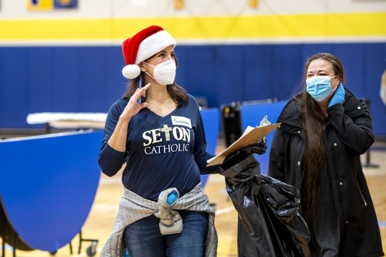 Parent volunteer Suzanne Gerhart, left, helps toy drive shopper Amy Buie on Saturday, December 19, 2020, at Seton Catholic Prep School. The toy drive was put on by St. Vincent De Paul, who used Seton Catholic’s facilities and student and parent volunteers to serve the community. Guests were sheparded through the gymnasium and cafeteria to pick out toys, clothing, books, wrapping paper and enter raffles for a bike and a Christmas tree.