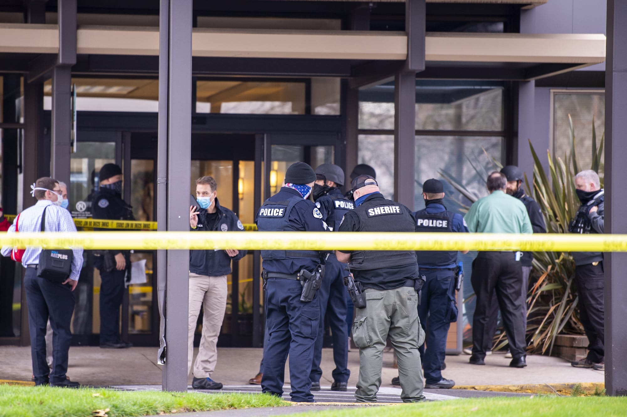 Police officers and officials congregate outside the building where a shooting reportedly happened on Tuesday, December 22, at the 505 building at the PeaceHealth Southwest Medical Center.