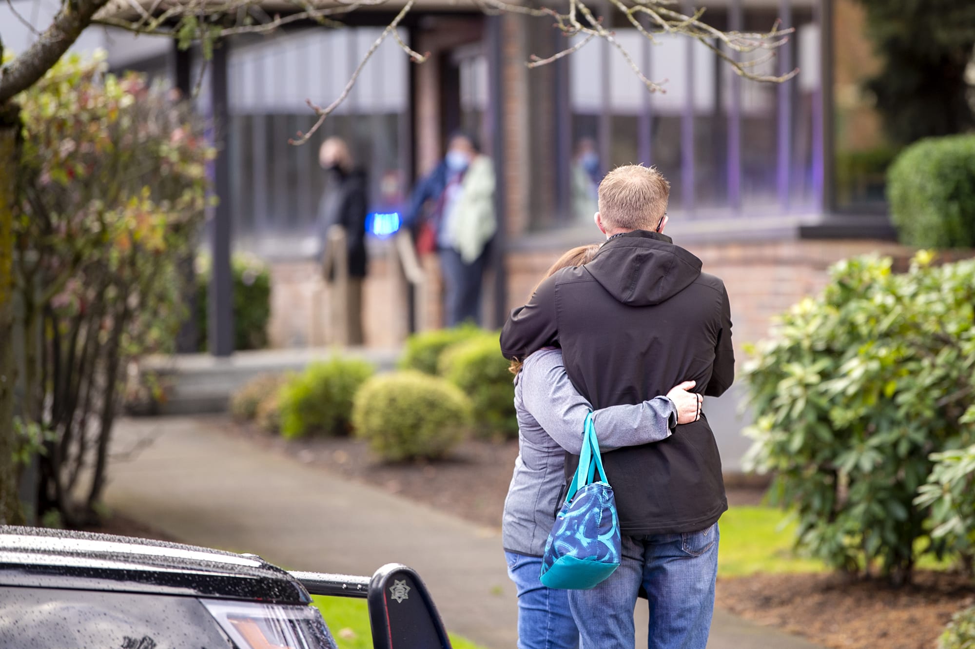 Two people embrace outside of the building where a shooting reportedly happened on Tuesday, December 22, at the 505 building at the PeaceHealth Southwest Medical Center.