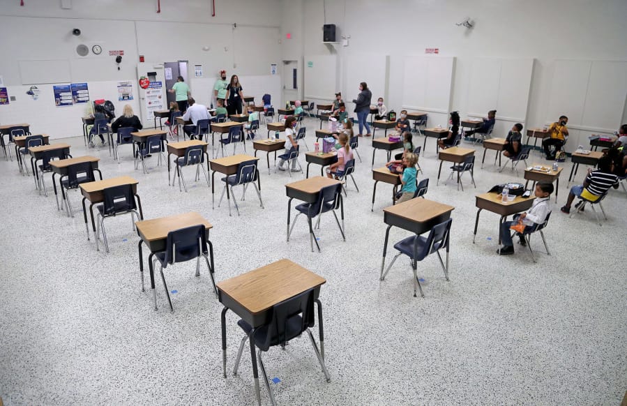 Students eat lunch in the cafeteria during the first day of face-to-face eLearning at Plantation Park Elementary School in Plantation, Florida on Friday, Oct. 9, 2020. Trump administration officials are trying to reduce nutrition requirements for school meals.