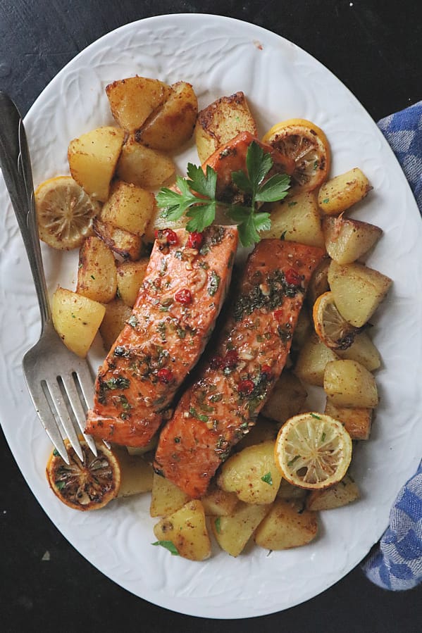 Salmon marinated in a spicy-sweet mix of brown sugar, soy sauce, ginger and chili is roasted along with potatoes for a quick and healthy dinner.
