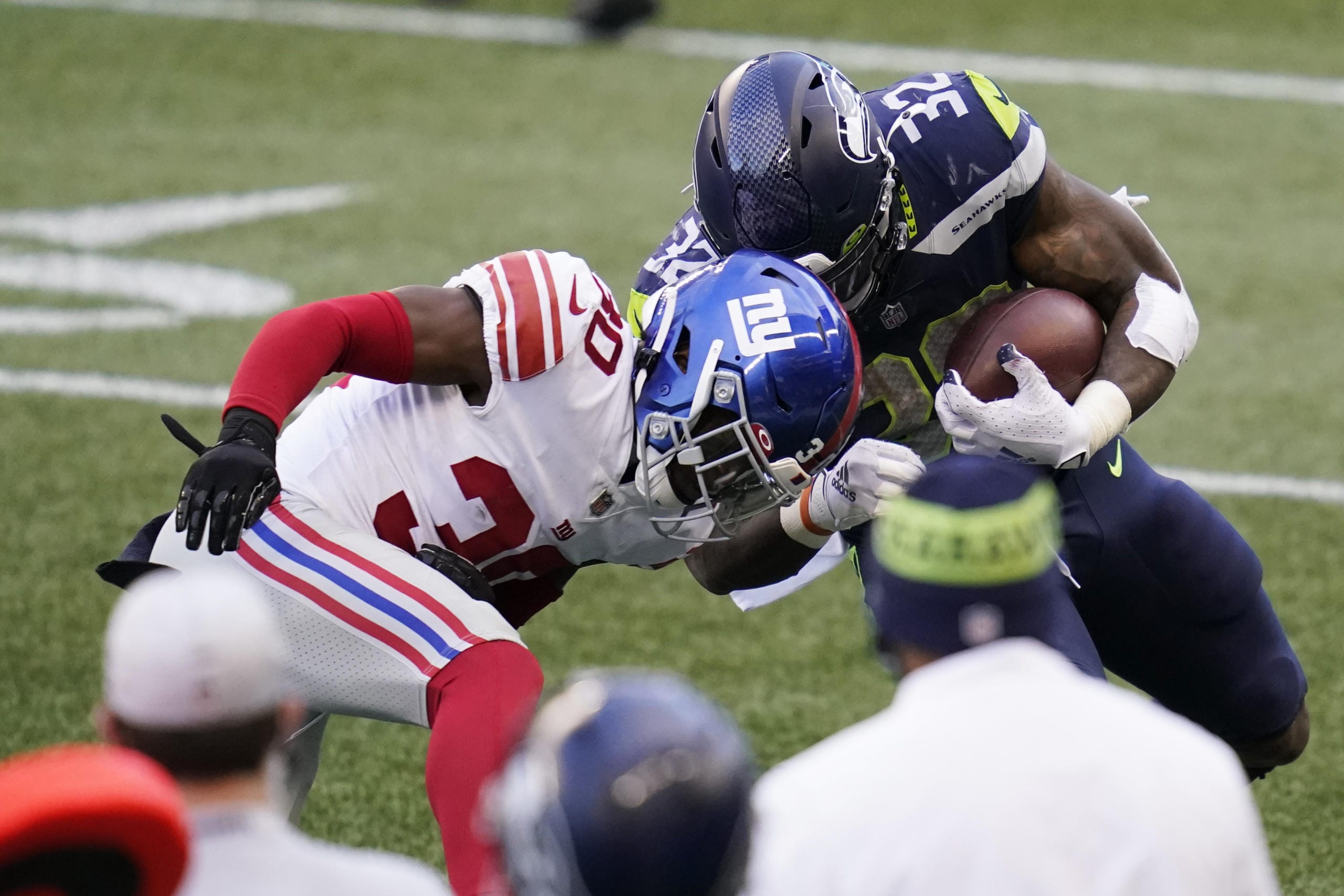 Seattle Seahawks running back Chris Carson (32) is stopped by New York Giants cornerback Darnay Holmes (30) during the second half of an NFL football game, Sunday, Dec. 6, 2020, in Seattle.