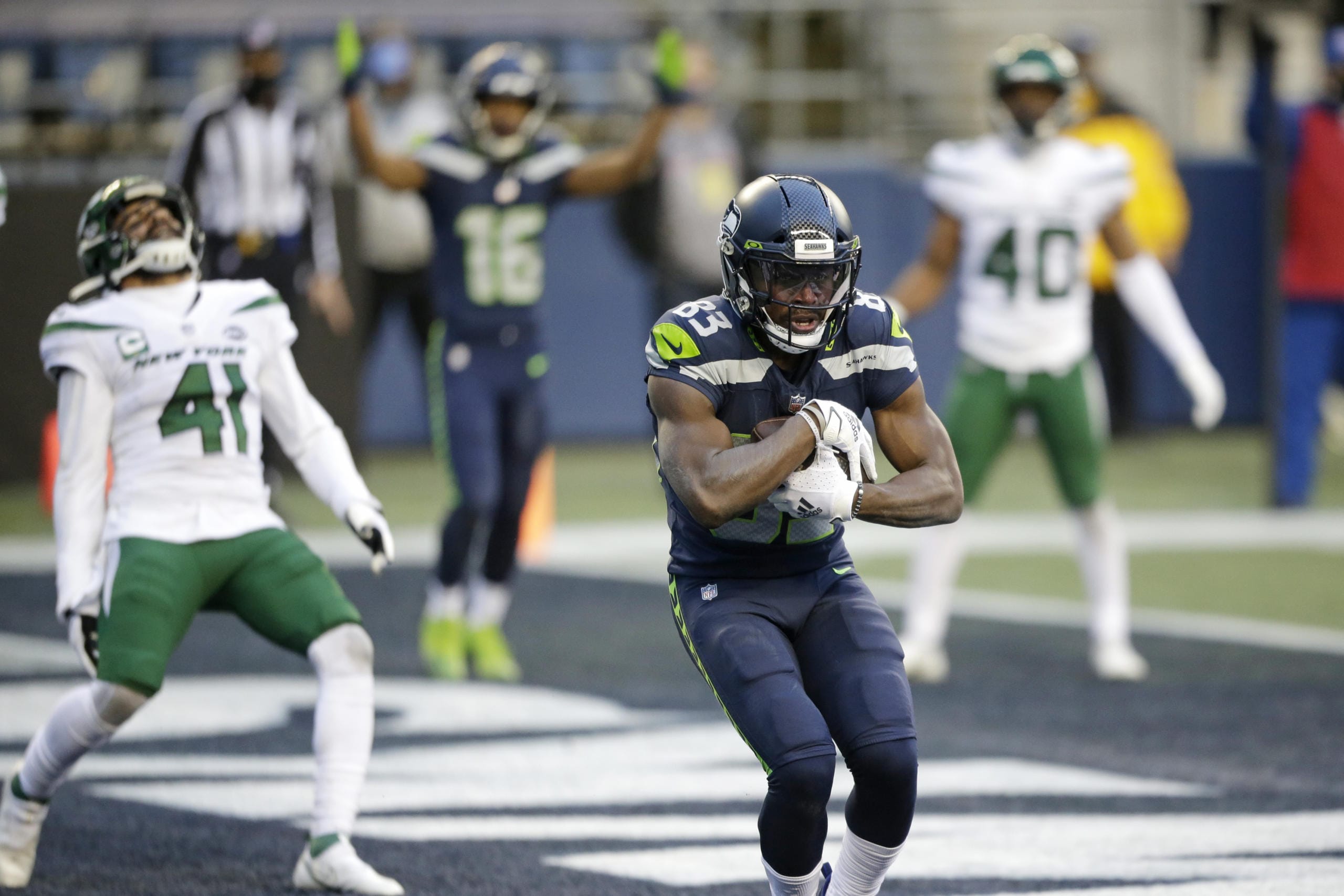 Seattle Seahawks wide receiver David Moore cradles the ball after catching a touchdown pass as New York Jets safety Matthias Farley (41) reacts behind during the second half of an NFL football game, Sunday, Dec. 13, 2020, in Seattle.