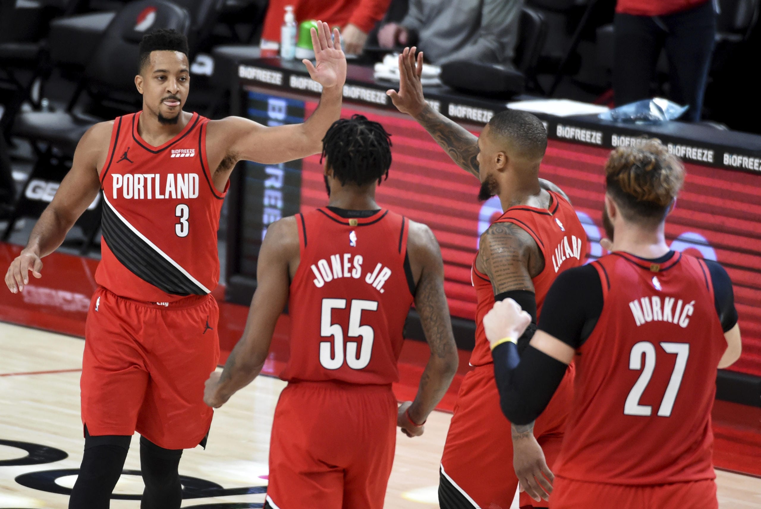 Portland Trail Blazers guard CJ McCollum, left, celebrates with teammates after hitting a shot to give the Blazers the lead late in overtime of an NBA basketball game against the Houston Rockets in Portland, Ore., Saturday, Dec. 26, 2020. The Blazers won 128-126.