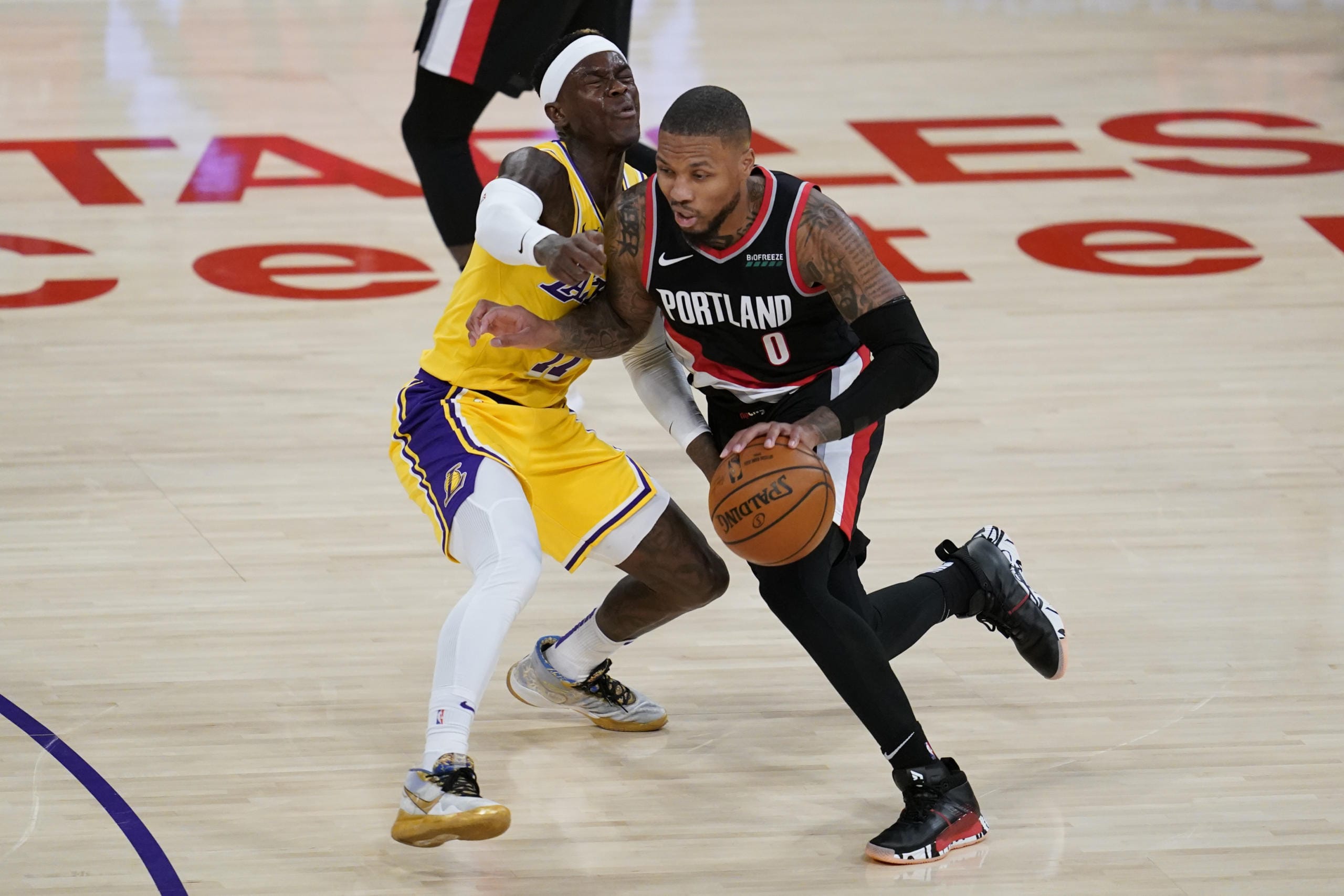 Portland Trail Blazers guard Damian Lillard, right, fouls Los Angeles Lakers guard Dennis Schroeder (17) during the second quarter of an NBA basketball game Monday, Dec. 28, 2020, in Los Angeles.