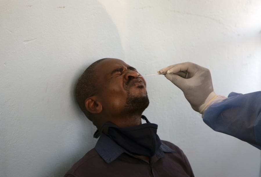 FILE -- In this Thursday, Dec. 24, 2020 file photo, a long-distance traveller undergoes a COVID-19 test at a mobile clinic at a taxi rank at Johannesburg&#039;s main railway station. As a result of holiday gatherings, African officials warn of a resurgence of COVID-19 on the continent and urge increased testing to combat it. The level of testing across Africa is considerably less than what health experts say is needed to effectively control the spread of the disease.
