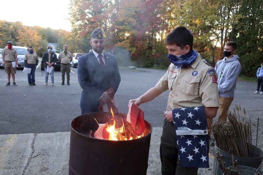 FILE - In this Tuesday, Oct. 13, 2020 file photo, Jondavid Longo, Republican mayor of Slippery Rock, Pa., center, presides over a Boy Scouts flag retirement ceremony where worn out flags are cut up and burned in Slippery Rock. Longo says the 2020 election has changed politics in his town, surfacing resentments from voters on both sides. The lingering tensions now overshadow issues once considered local -- such as funding the police and libraries.