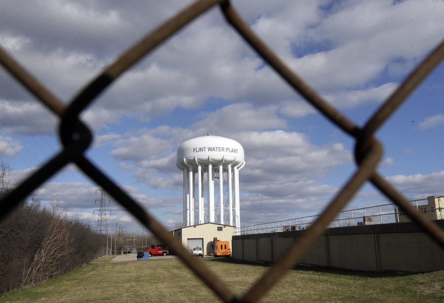 FIL - In this March 21, 2016, file photo the Flint Water Plant water tower is seen in Flint, Mich. Michigan Gov. Gretchen Whitmer says a proposed $600 million deal between the state of Michigan and Flint residents harmed by lead-tainted water is a step toward making amends. Officials announced the settlement Thursday, Aug. 20, 2020, which must be approved by a federal judge.