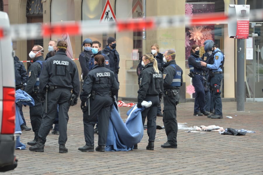 Police officers and firefighters stay together at the scene of an incident in Trier, Germany, Tuesday, Dec. 1, 2020.  German police say people have been killed and several others injured in the southwestern German city of Trier when a car drove into a pedestrian zone. Trier police tweeted that the driver had been arrested and the vehicle impounded.