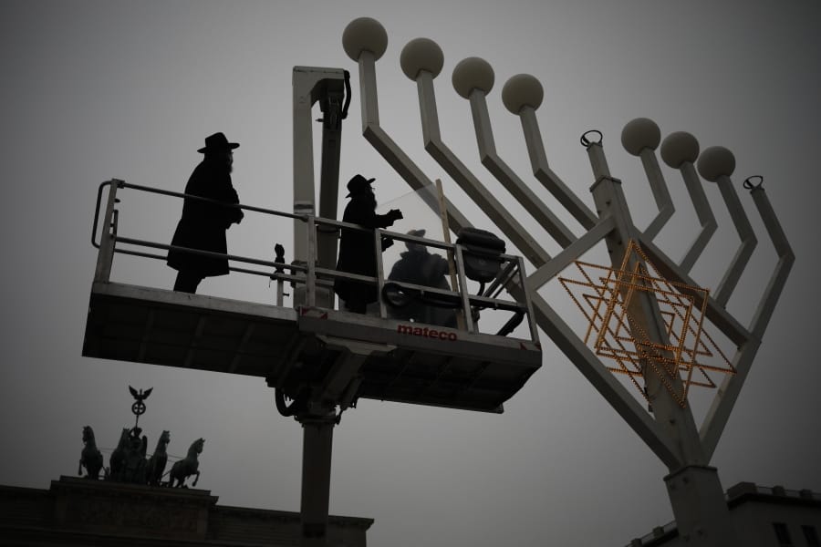 Rabbi Yehuda Teichtal, left, and Rabbi Segal Shmoel, second from left, inspect a giant Hanukkah Menorah, set up by the Jewish Chabad Educational Center on Thursday ahead of the Jewish Hanukkah holiday, at the Pariser Platz in Berlin, Germany.