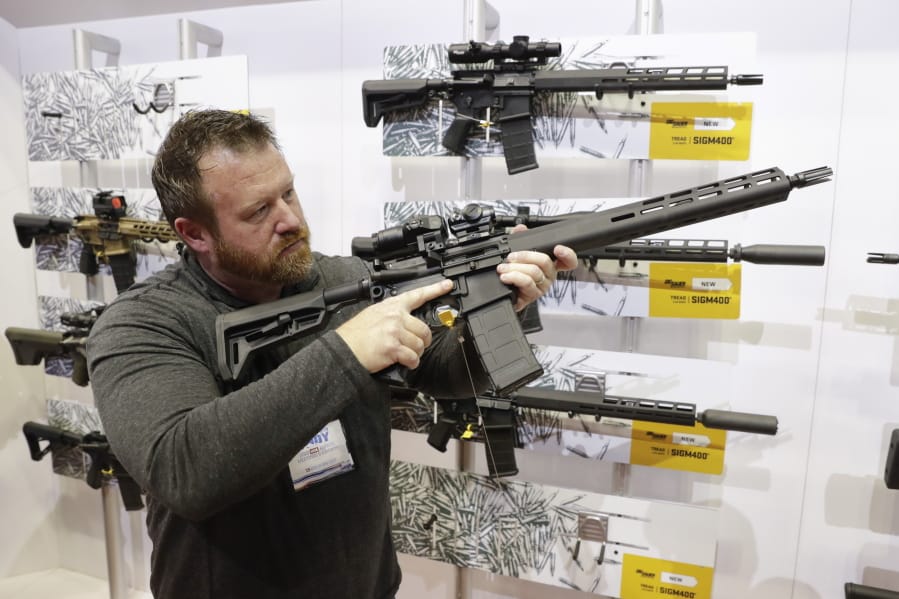 FILE - Bryan Oberc, Munster, Ind., tries out an AR-15 from Sig Sauer in the exhibition hall at the National Rifle Association Annual Meeting in Indianapolis, Saturday, April 27, 2019. Efforts to impose restrictions on firearms will soon have a supporter in the White House. But it&#039;s unlikely that big ticket items gun-control advocates have pined for will have much chance of passage given the tight margins in Congress and the increased polarization over gun issues. Much has changed in the past 12 years: more Americans own firearms and there are more AR-platform firearms in the civilian market.