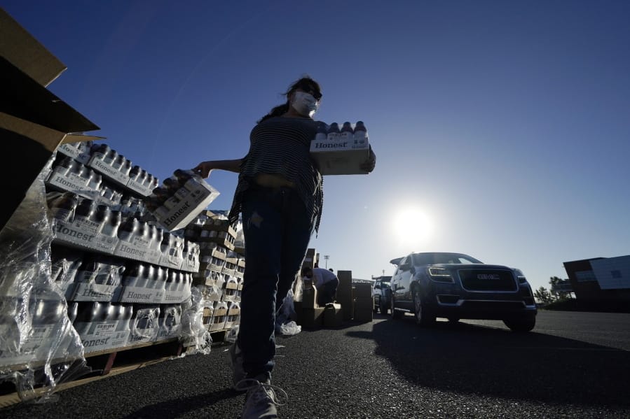 Volunteers distribute food to people who waited in line in their cars overnight, at a food distribution point in Metairie, La., Thursday, Nov. 19, 2020.