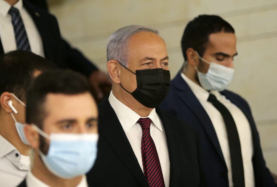 Israeli Prime Minister Benjamin Netanyahu, center, arrives at the Israeli Knesset (Parliament) ahead of a vote to dissolve the Knesset, in Jerusalem, Wednesday, Dec. 2 2020.