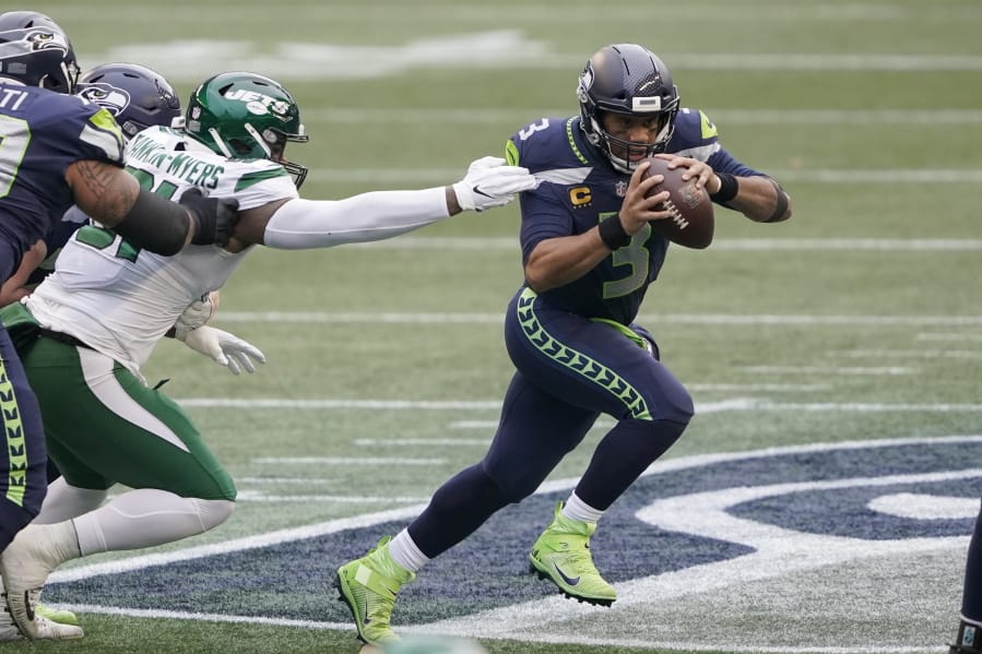 Seattle Seahawks quarterback Russell Wilson, right, scrambles against the New York Jets during the first half of an NFL football game, Sunday, Dec. 13, 2020, in Seattle. (AP Photo/Ted S.