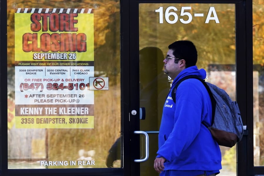 FILE - In this Friday, Nov. 6, 2020, file photo, a man walks past a closed store in Wilmette, Ill., amid the coronavirus pandemic. Responses to the coronavirus pandemic and police brutality dominated legislative sessions in 2020 and led to many new laws that will take effect in the new year. (AP Photo/Nam Y.