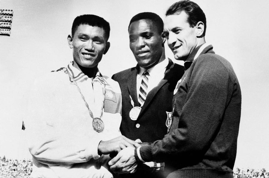 FILE - In this Sept. 7, 1960, file photo, Rafer Johnson of Kingsburg, Calif., is flanked by runners-up, Chuan-Kwang Yang, left, of Taiwan, and Vasily Kuznetsov of Russia, as they join in three-way handshake after receiving medals for the decathlon event of the Olympics in Rome, Italy. Rafer Johnson, who won the decathlon at the 1960 Rome Olympics and helped subdue Robert F. Kennedy&#039;s assassin in 1968, died Wednesday, Dec. 2, 2020. He was 86. He died at his home in the Sherman Oaks section of Los Angeles, according to family friend Michael Roth.
