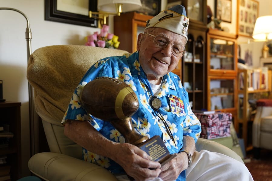 Mickey Ganitch, a 101-year-old survivor of the attack on Pearl Harbor, holds a football statue he was given, in the living room of his home in San Leandro, Calif., Nov. 20, 2020. Ganitch was getting ready for a match pitting his ship, the USS Pennsylvania, against the USS Arizona when Japanese planes bombed Pearl Harbor on Dec. 7, 1941. The game never happened. Instead, Ganitch spent the morning, still in his football uniform, looking out for attacking planes that anti-aircraft gunners could shoot down.