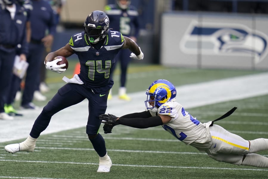 Seattle Seahawks wide receiver DK Metcalf (14) runs after a reception as Los Angeles Rams cornerback Troy Hill (22) attempts the tackle during the first half of an NFL football game, Sunday, Dec. 27, 2020, in Seattle.