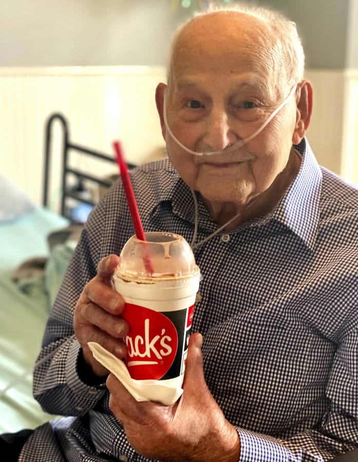 In this photo provided by Holly Wooten McDonald, World War II veteran and COVID-19 survivor Major Wooten holds a celebratory milkshake on his 104th birthday on Thursday, Dec. 3, 2020, in Madison, Alabama. Wooten was released from the hospital this week after contracting the illness caused by the new coronavirus before Thanksgiving.