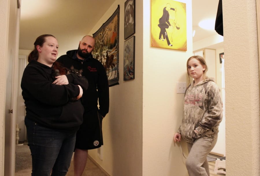 FILE - In this Dec. 11, 2020, file photo, Taylor Wood and her boyfriend, Ryan Bowser, talk to Wood&#039;s 10-year-old daughter, Freya Wood, in Corvallis, Ore. The family, which has been living in the apartment for more than two years, has missed three rent payments during the pandemic. As the economic effects of the coronavirus pandemic stretch into 2021, millions of U.S. renters are bracing for the possibility of having to show up in housing court to avoid getting evicted. But unlike their landlords, only a small fraction of them will do so flanked by an attorney.