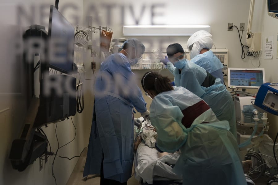 EMT Giselle Dorgalli, second from right, looks at a monitor Nov. 19 while performing chest compressions on a patient who tested positive for coronavirus in the emergency room at Providence Holy Cross Medical Center in the Mission Hills section of Los Angeles. (Jae C.
