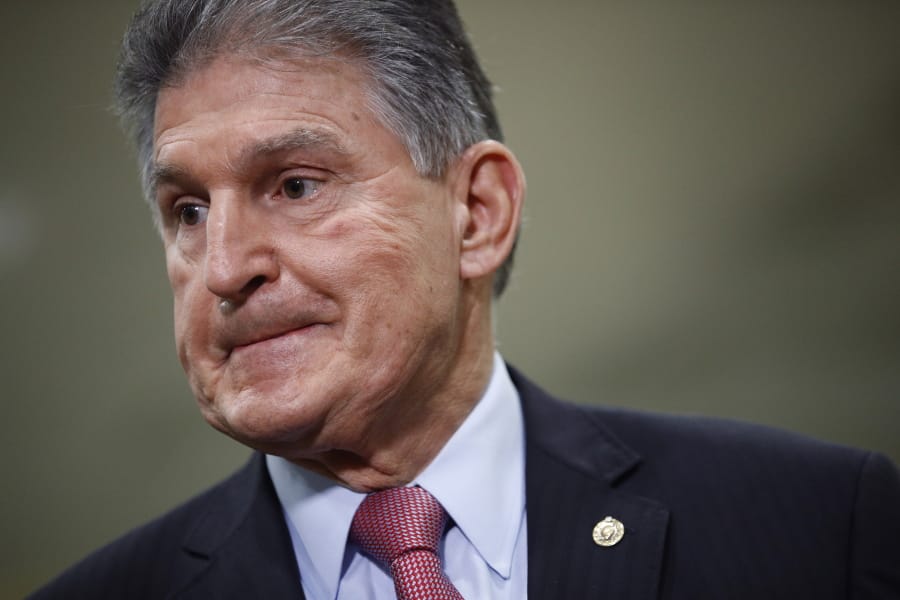 FILE - In this Feb. 5, 2020, file photo, Sen. Joe Manchin, D-W.Va., speaks with reporters on Capitol Hill in Washington. A bipartisan group of lawmakers, including Manchin,  is putting pressure on congressional leaders to accept a split-the-difference solution to the months-long impasse on COVID-19 relief in a last-gasp effort to ship overdue help to a hurting nation before Congress adjourns for the holidays.