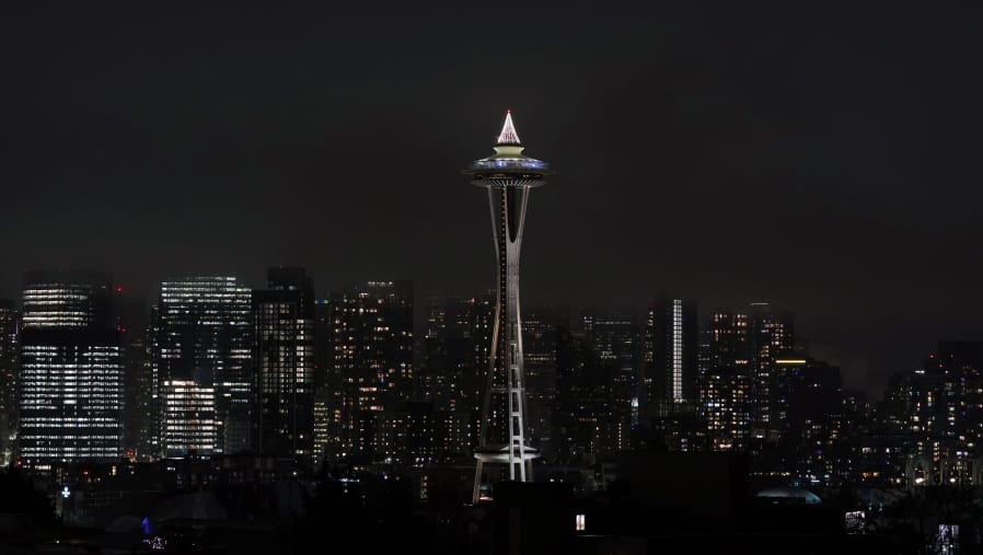 As clouds obscure taller buildings in the background, the Space Needle is shown with holiday lights on top, Monday, Dec. 21, 2020, as viewed from Kerry Park in Seattle. (AP Photo/Ted S.
