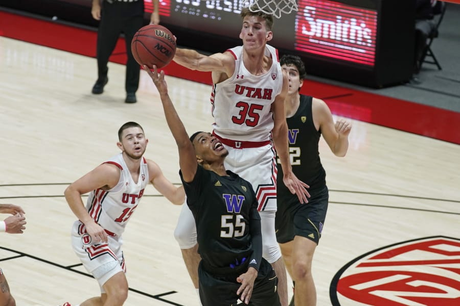 Utah center Branden Carlson (35) defends against Washington guard Quade Green (55) as he goes to the basket during the first half of an NCAA college basketball game Thursday, Dec. 3, 2020, in Salt Lake City.